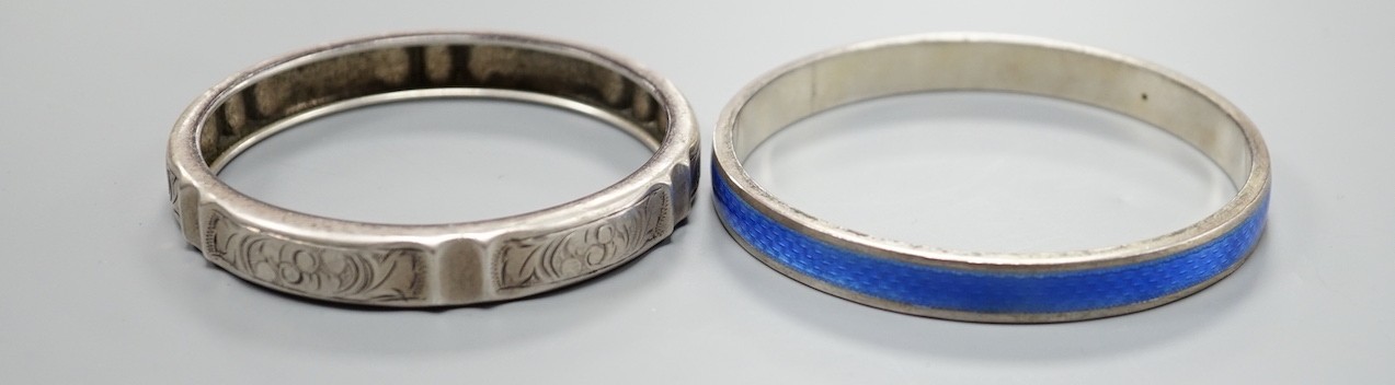 A 1920's silver and blue enamel bangle and an engraved white metal bangle.